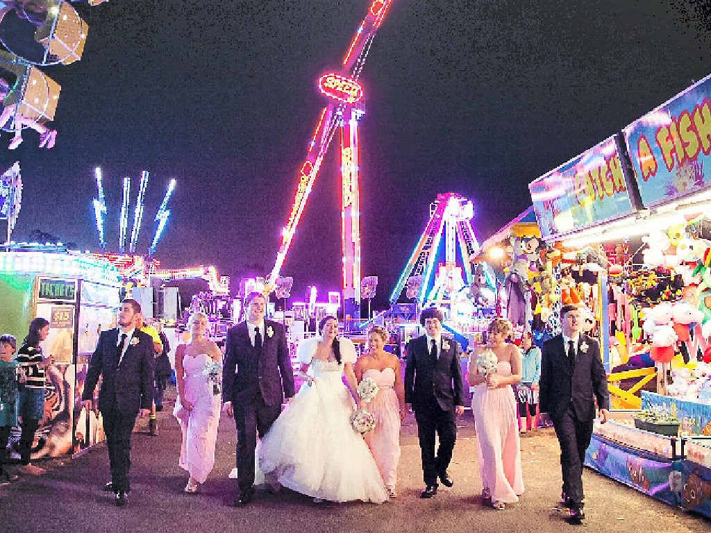 SHOW FUN: Peter and Lauren Tryhorn, joined by their bridal party, stroll down Sideshow Alley at the weekend’s Gympie Show.LEFT: The happy couple shares an intimate moment. SHOW FUN: Peter and Lauren Tryhorn, joined by their bridal party, stroll down Sideshow Alley at the weekend’s Gympie Show.LEFT: The happy couple shares an intimate moment.